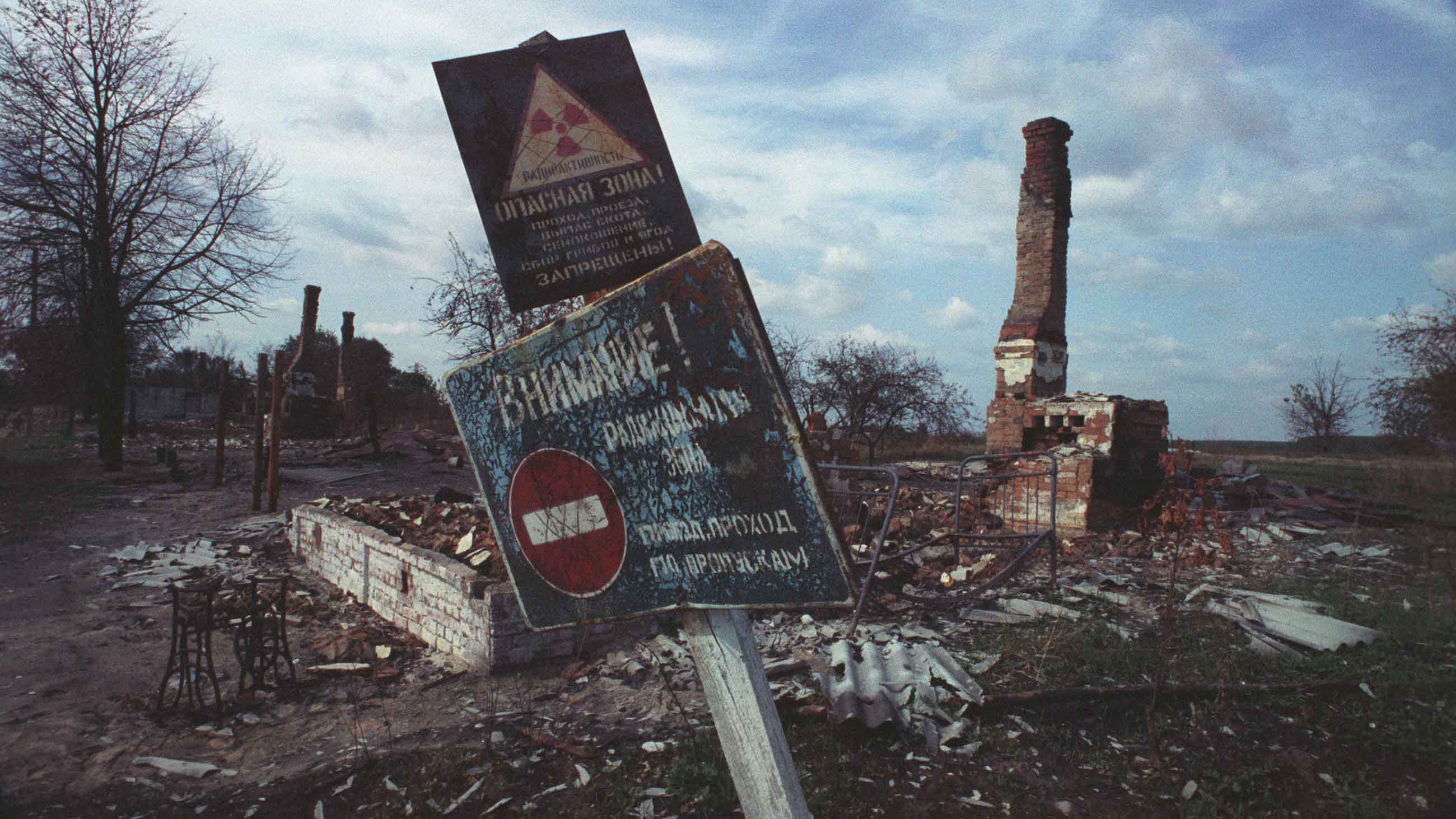 Part of the village of Sviatsk in the Bryansk region lies in ruins after it was destroyed by liquidators. All that remains to destroy are the old Russian stoves and their chimneys. The sign reads "Attention, radioactive zone. Authorized passage only" and "Dangerous Zone! Walking, Grass, Mushroom and Bay Picking is Strictly Forbidden." (Photo by Igor Kostin/Sygma via Getty Images)