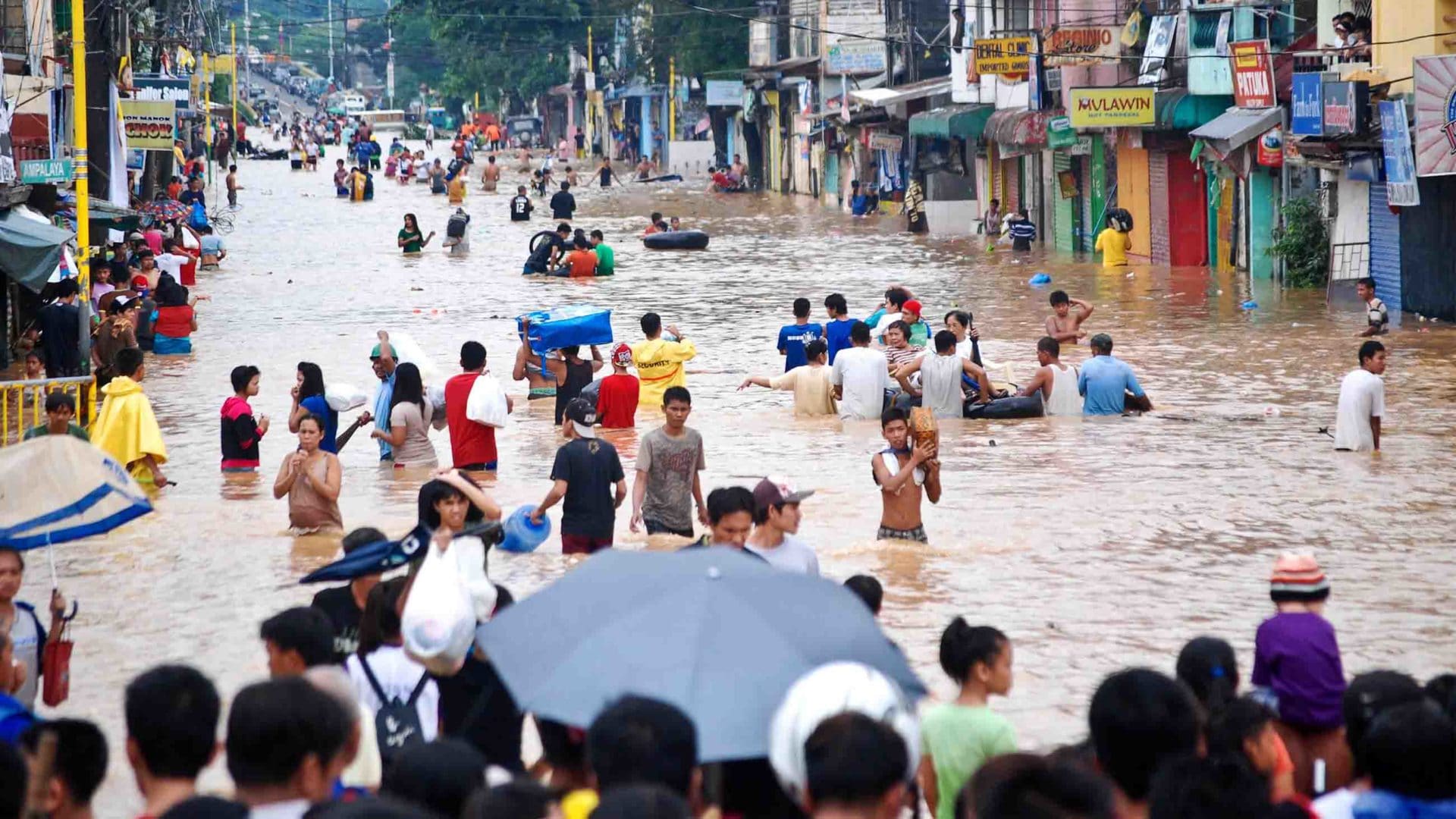 Residents of Manila cross floodwaters after torrential rains caused heavy flooding in the Philippines on August 8, 2012. The Philippines are among the low-lying nations most at risk of flooding from rising sea levels.