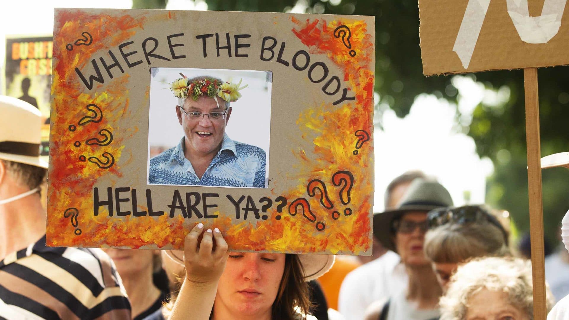 A protester holds up a banner scolding Prime Minister Scott Morrison during a December demonstration in Sydney, Australia.