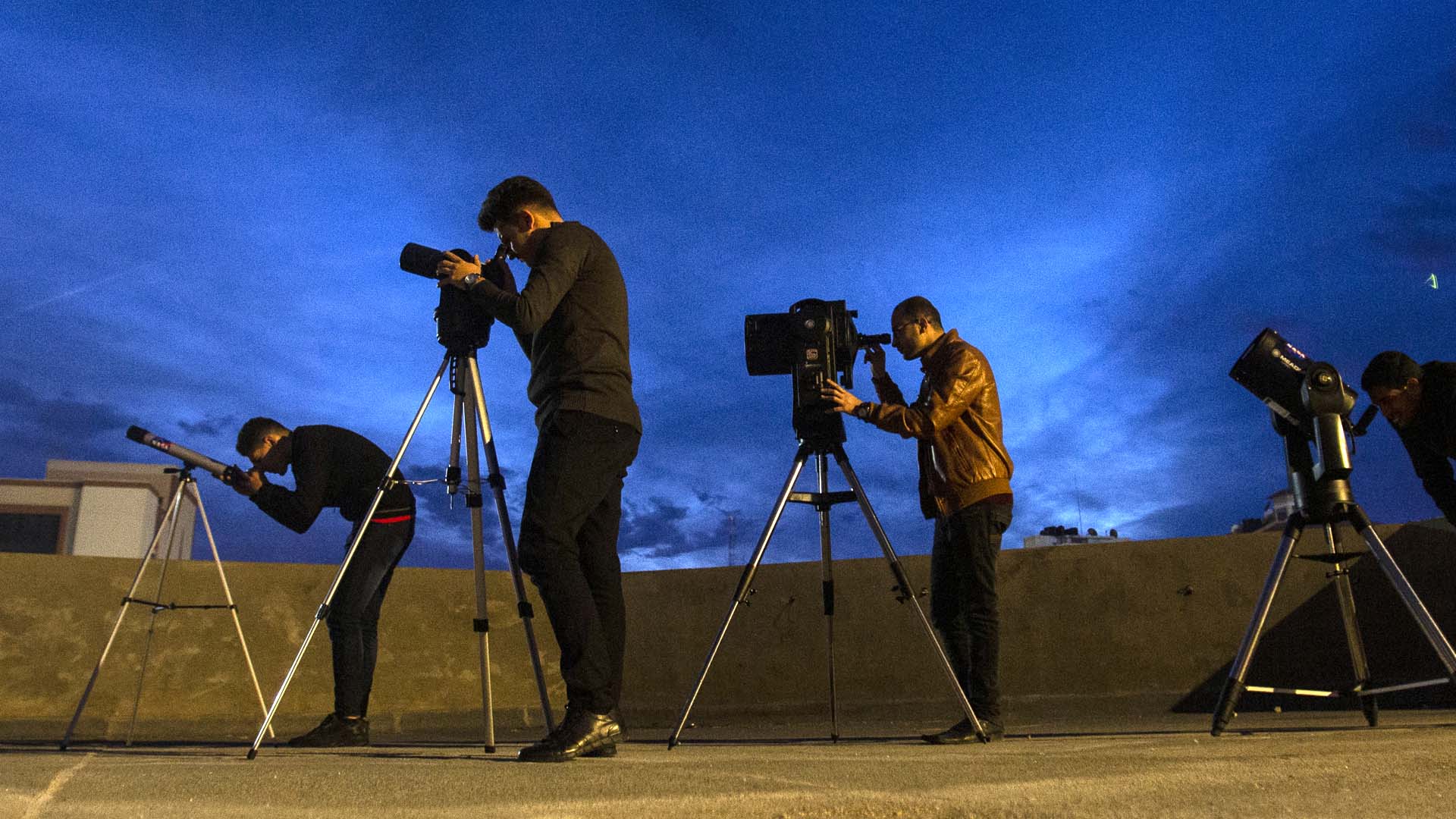 From left to right: Ibrahim Saad, Mohammad Baraka, and colleagues point their telescopes skyward from a rooftop of one of the buildings of al-Aqsa University in Gaza City on December 11, 2019.