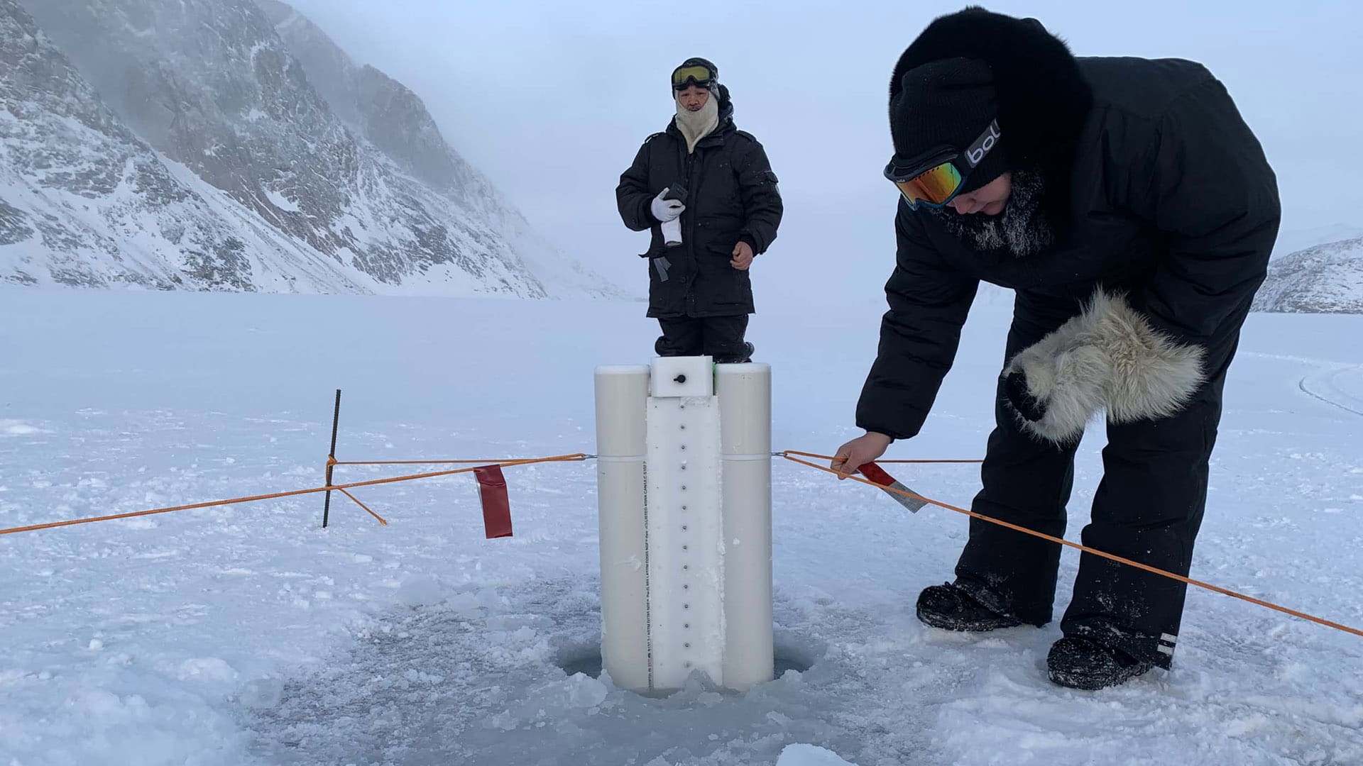 The SmartICE team monitors the SmartBUOY, an advanced data acquisition and remote monitoring climate change adaptation tool, in the landfast ice around the community of Qikiqtarjuaq, Nunavut.