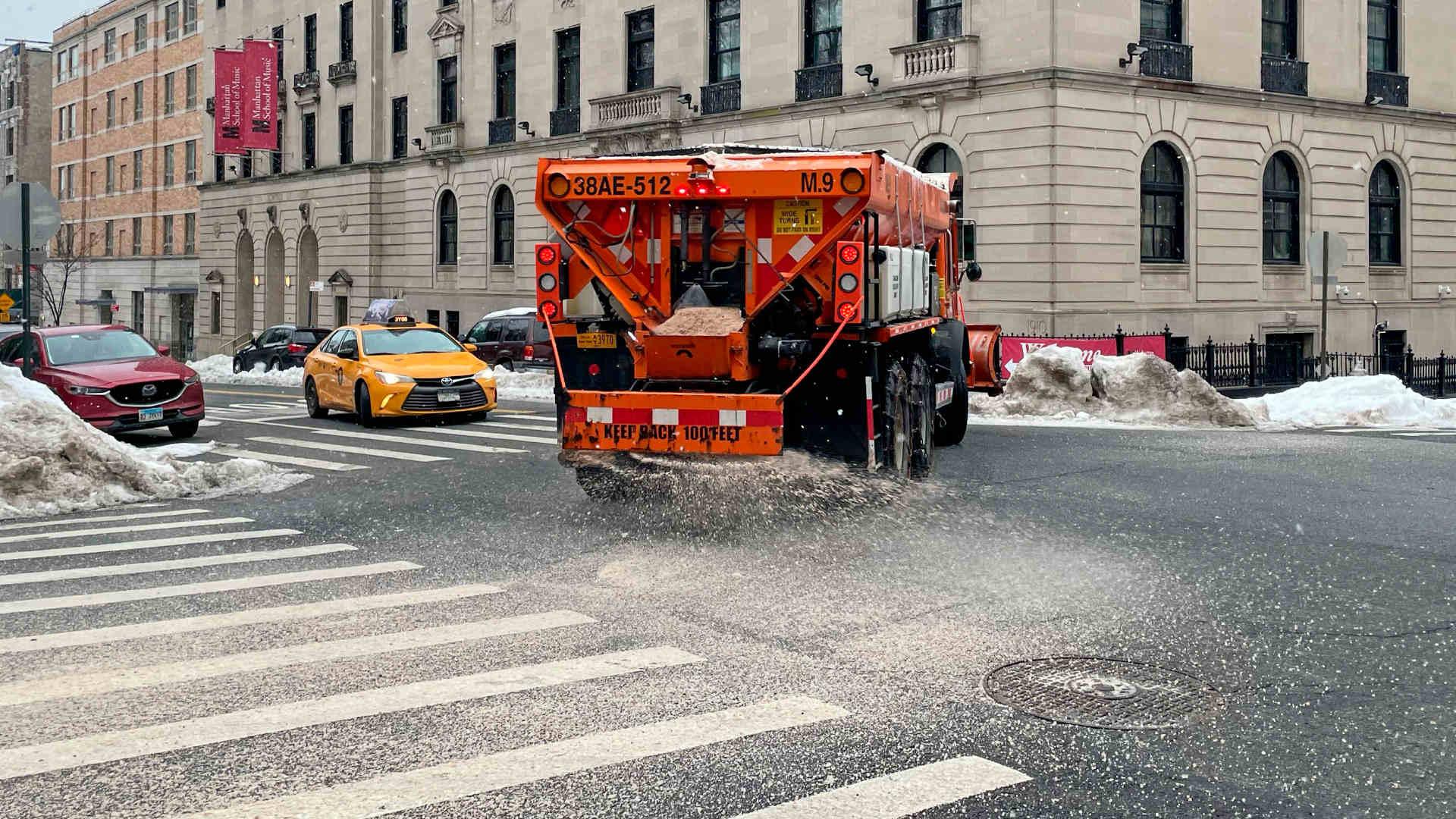 A truck spreads salt and sand on a Manhattan, New York street before a snowstorm.