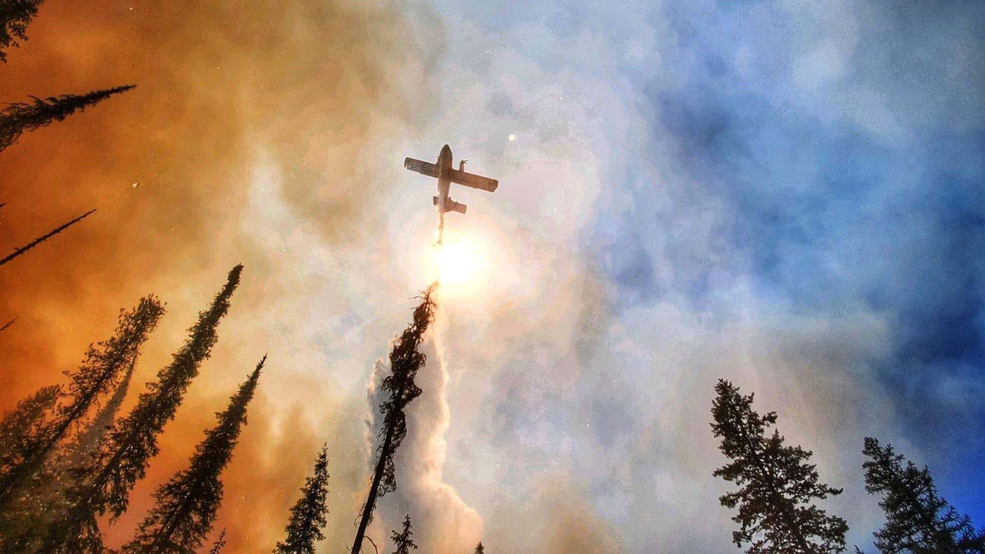 A large airtanker makes a water drop on the Summit Trail Fire in Washington in July 2021.