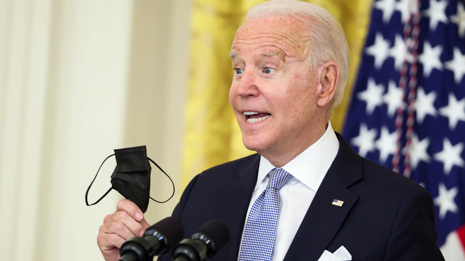 President Joe Biden holds up a face mask as he delivers remarks on his administration's effort to get more Americans vaccinated on July 29, 2021.