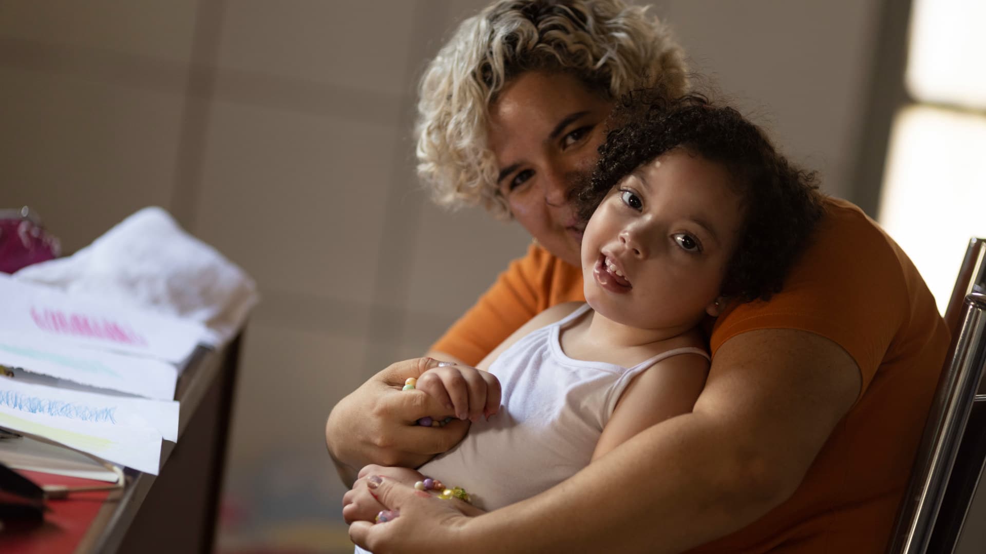 Rochelle dos Santos embraces her daughter, who was born with microcephaly in 2016 after dos Santos contracted Zika during her pregnancy in midwest Brazil. ALL PHOTOS BY UESLEI MARCELINO for UNDARK
