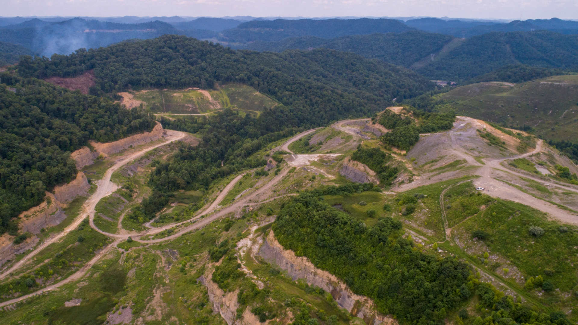 A mountain owned by Tracy Neece, right, and other strip mining in eastern Kentucky that awaits reclamation.