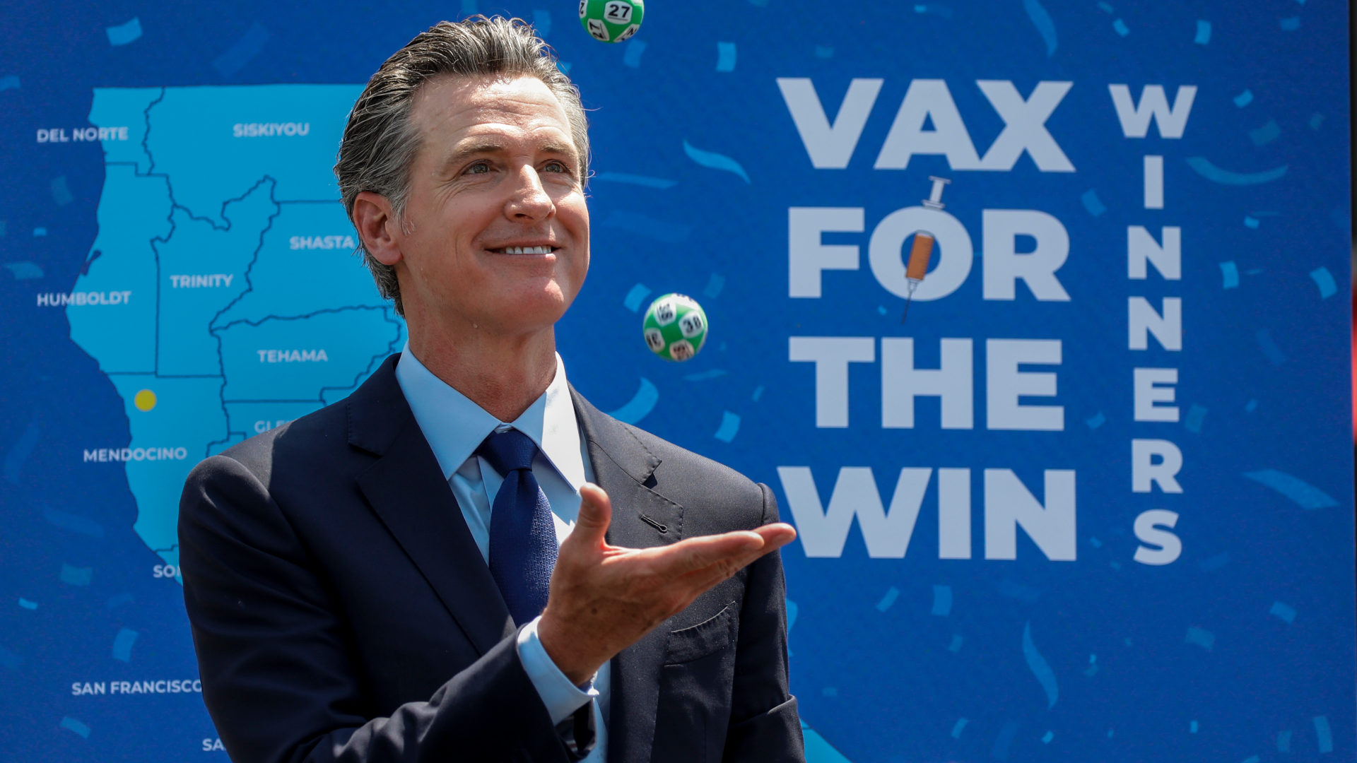 Governor Gavin Newsom juggles numbered balls during the drawing for California's "Vax for the Win" vaccine incentive program.