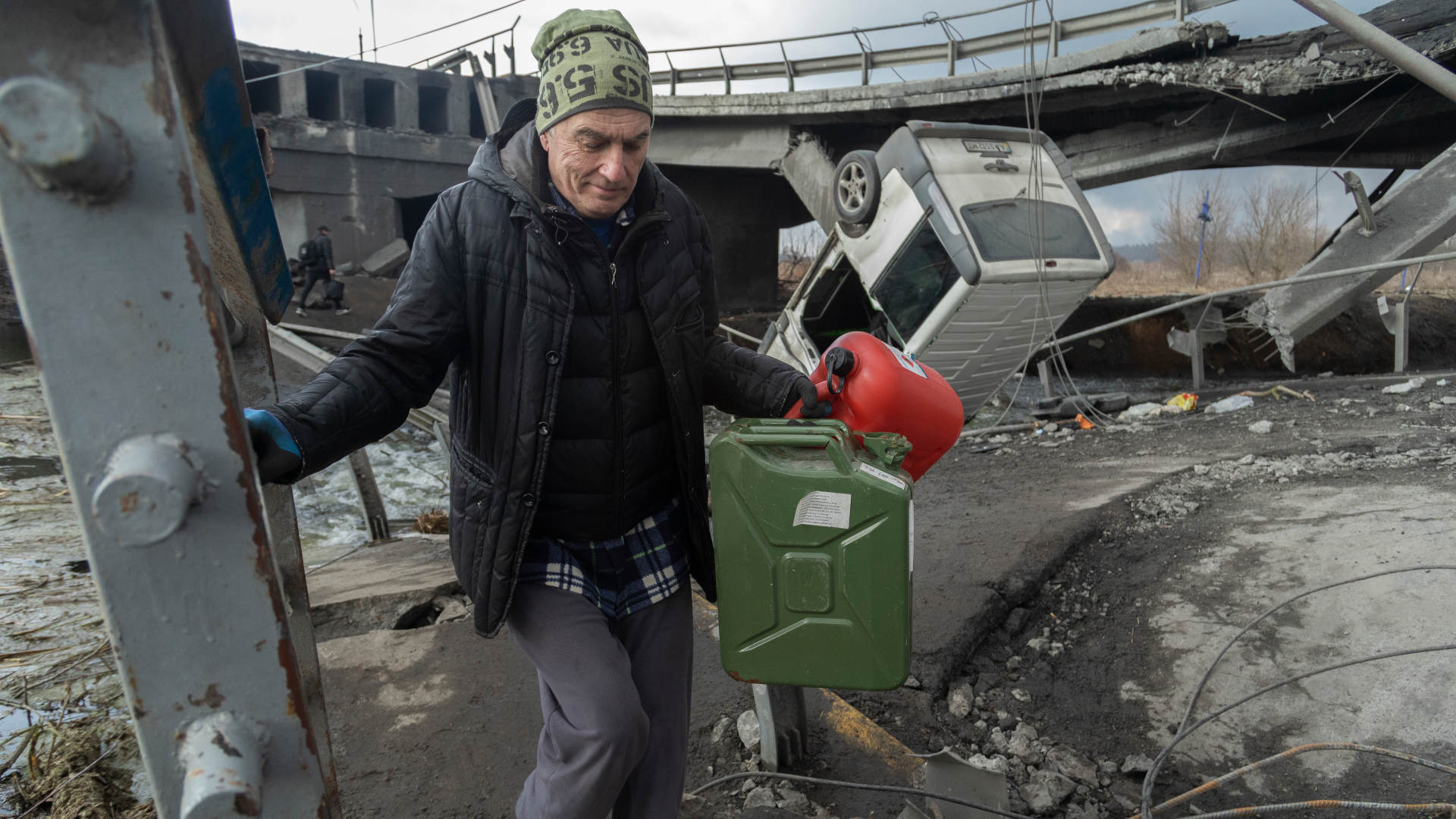 Ukrainian refugees fleeing Irpin cross a bombed bridge on March 4, 2022.