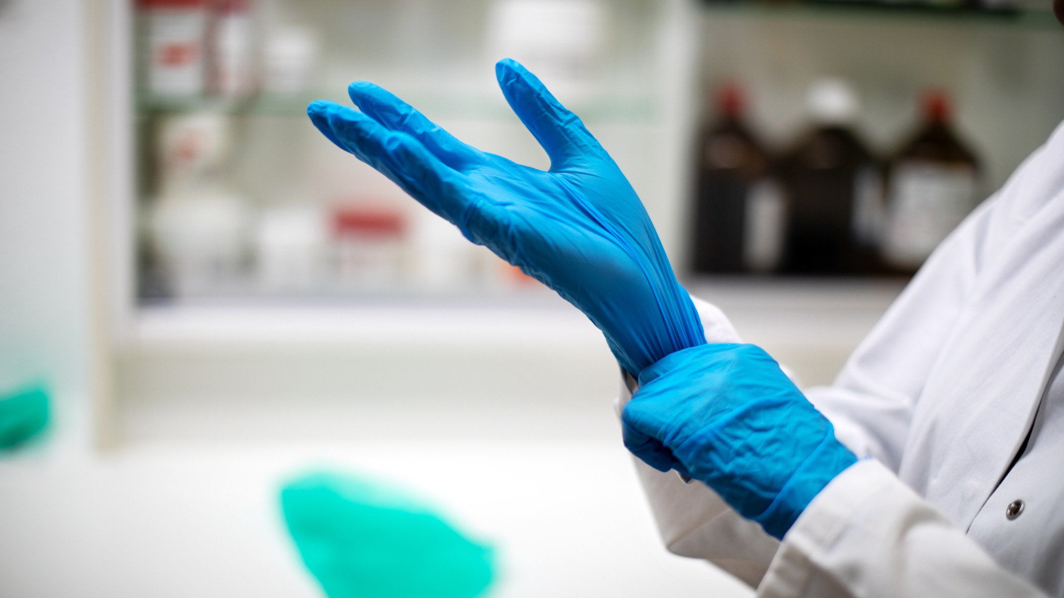 Gloved hands in a blurred lab setting