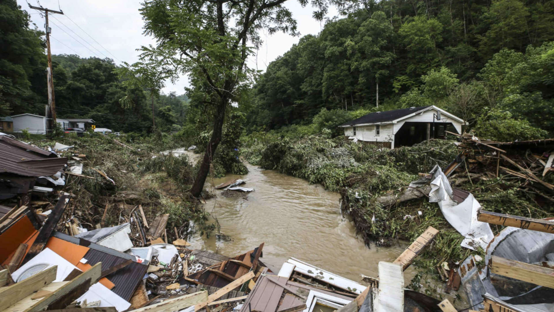 Debris from destroyed homes piles up near a concrete bridge over Grapevine Creek in Perry County after torrential rain caused flash flooding in Eastern Kentucky on July 28, 2022.