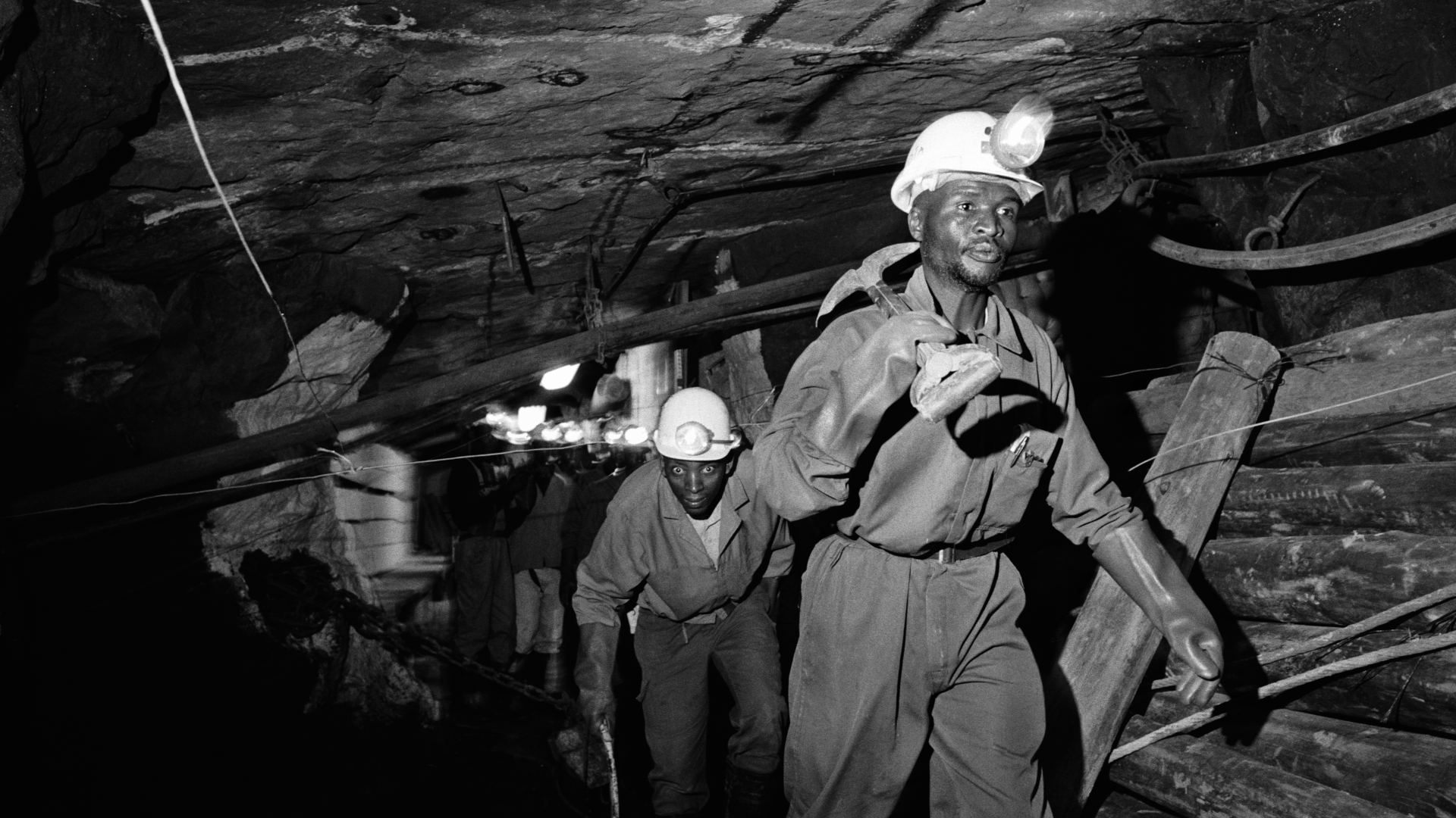 Miners working for the Lonmin Platinum company in South Africa walk along an underground tunnel in the early 2000s.