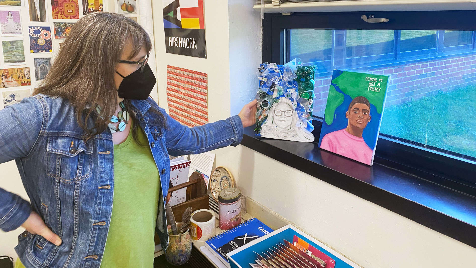 Carolyn McGrath, an art teacher at Central Valley High School, in
Pennington, New Jersey, shows off portraits of climate activists painted by her students.