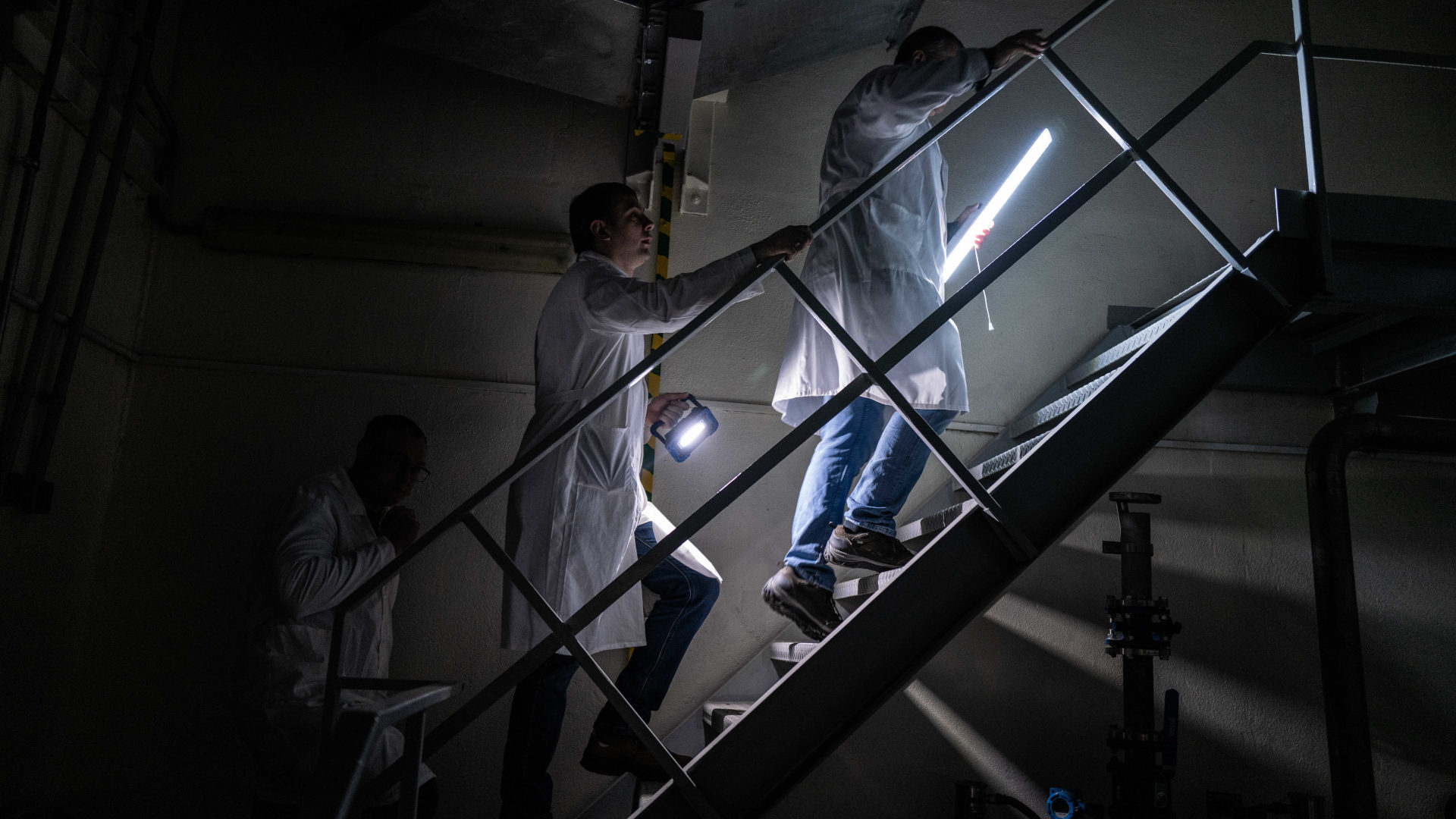 A group of technicians ascend stairs in the neutron source’s main reactor hall. Months after Russian rockets last landed on the grounds of the Kharkiv Institute of Physics and Technology, staff were still conducting repairs on the facility. | All photos by KERN HENDRICKS for UNDARK