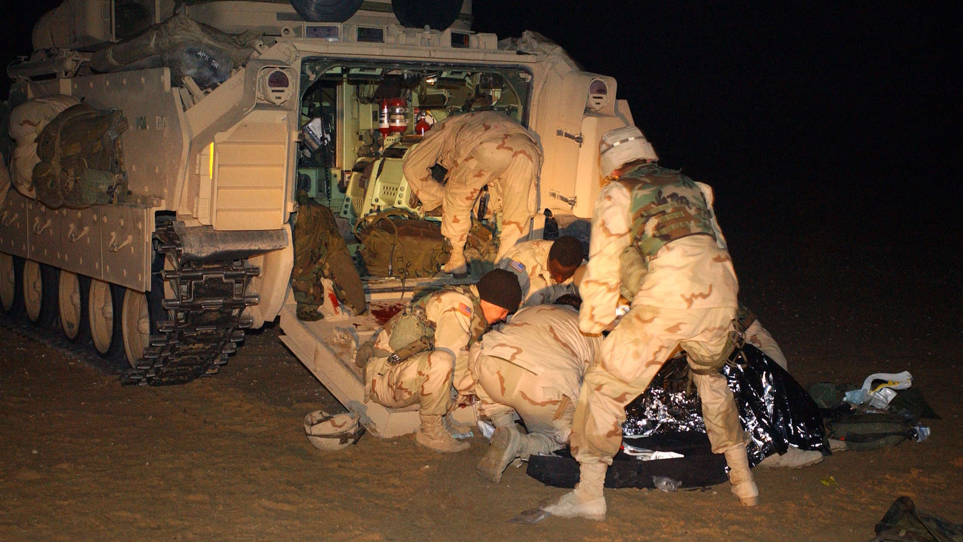 Medics treat an unidentified U.S. infantry soldier after he suffered injuries during a 2003 training accident near the Iraqi border in Kuwait.