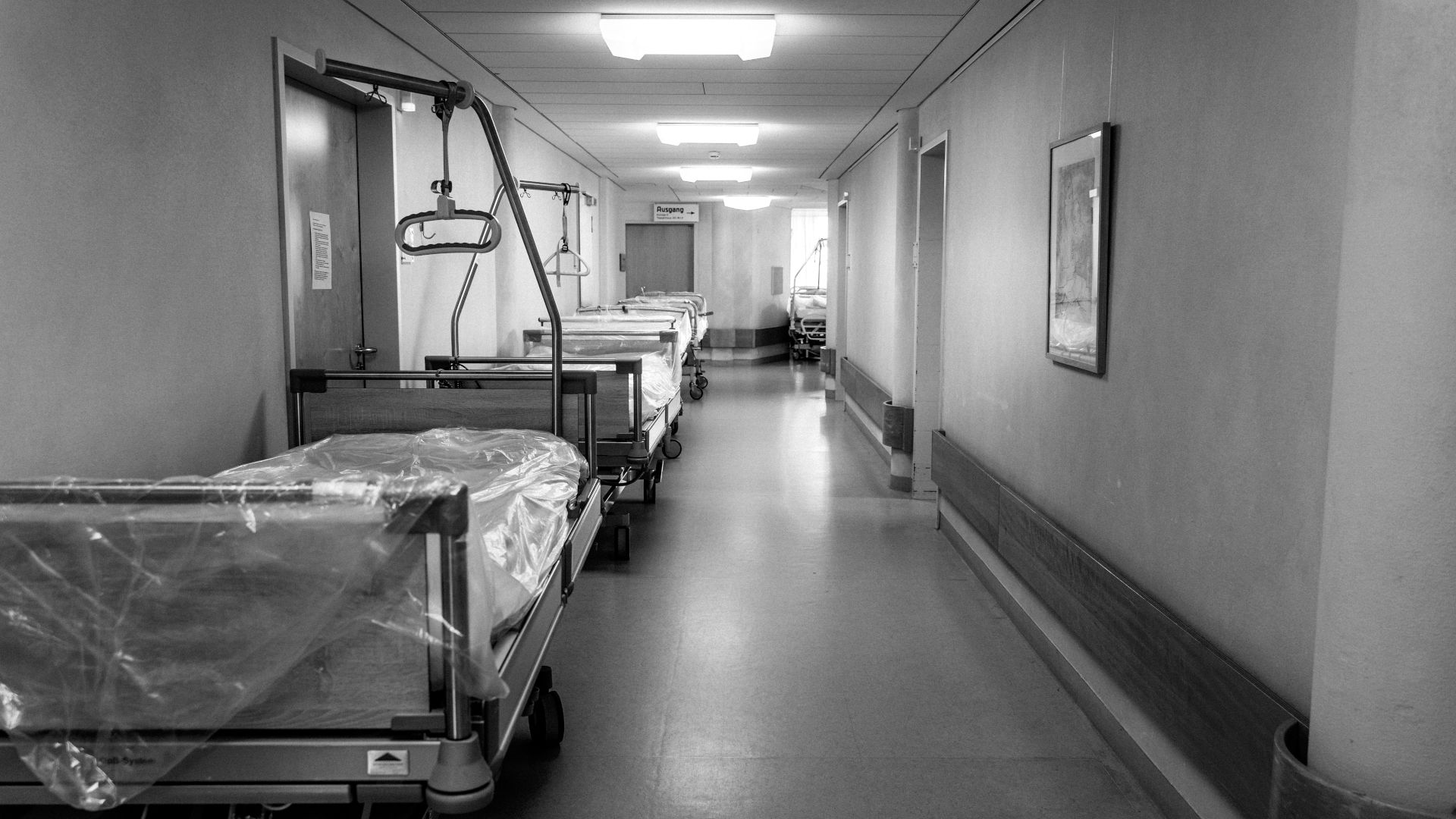A hospital hallway lined with empty beds.
