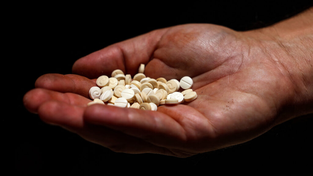 In 2022, a Lebanese security official holds a handful of confiscated Captagon pills in his palm.