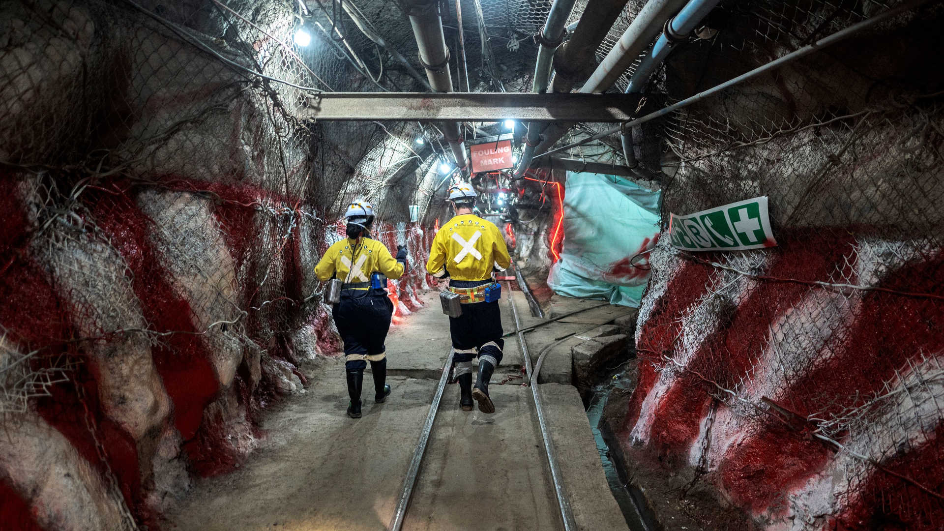 Staff members of the mining company Gold Fields walk in tunnels of the South Deep gold mine in Gauteng, South Africa in October 2022.