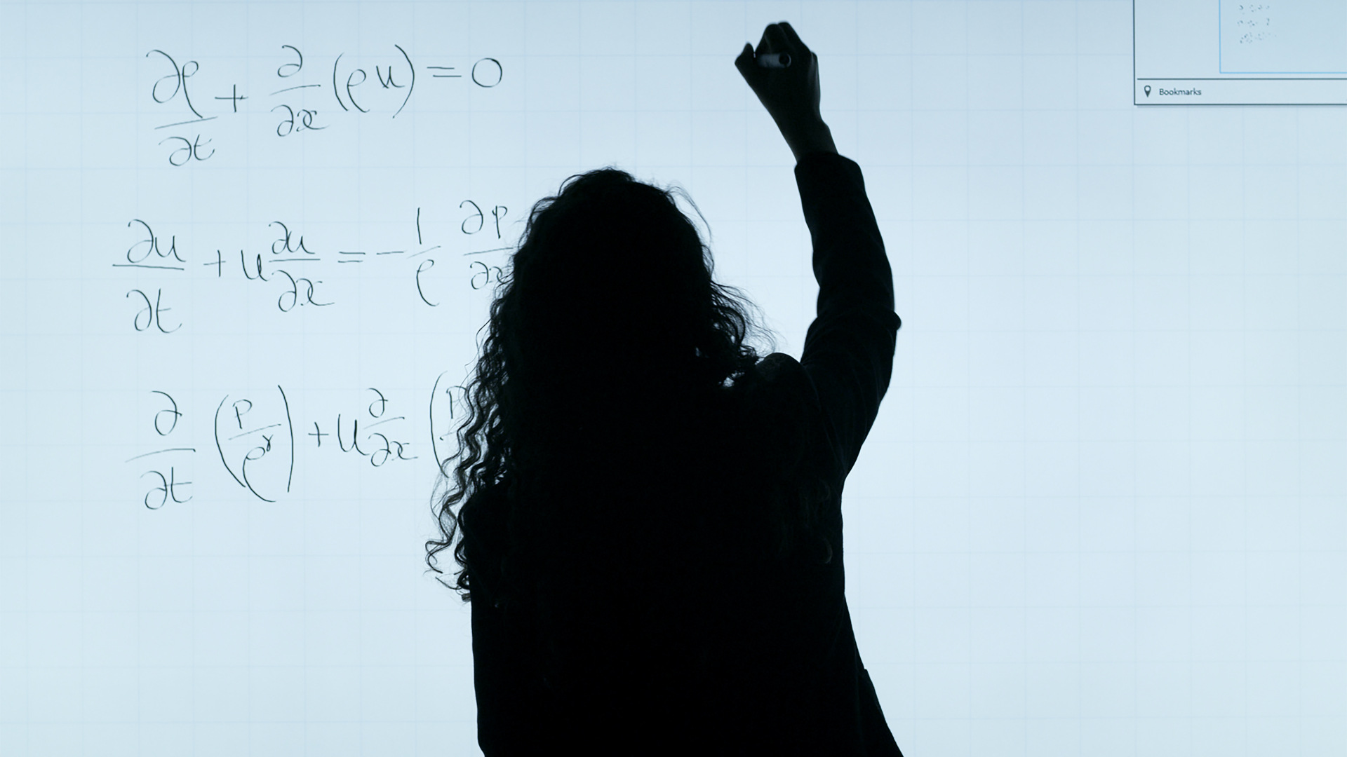 A black silhouette does math on a whiteboard