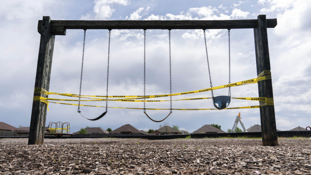 Security tape across children's swings during Covid-19 lockdown in Oklahoma.