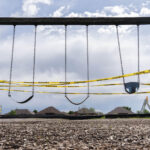 Security tape across children's swings during Covid-19 lockdown in Oklahoma.