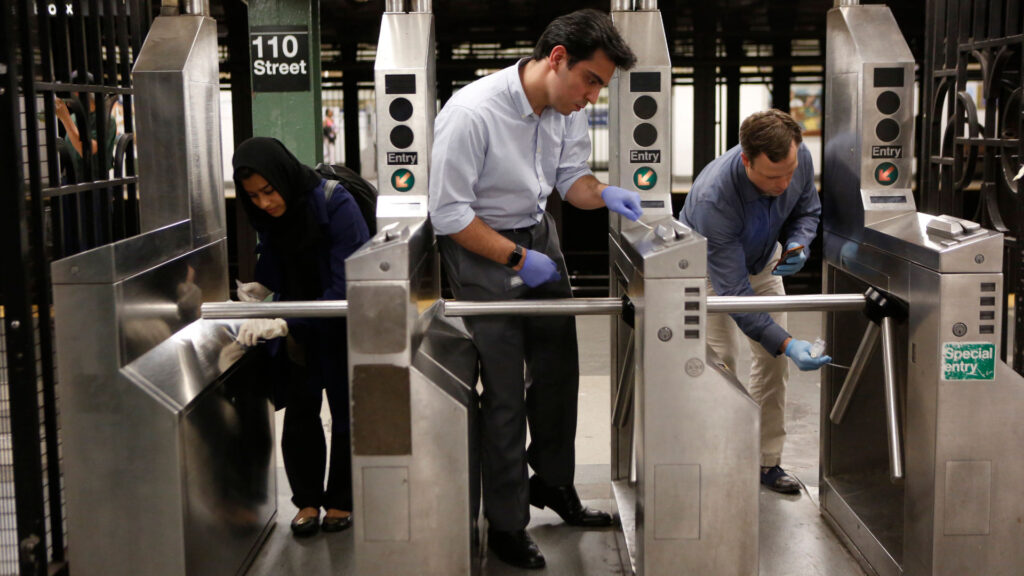 Geneticist Chris Mason (right), Evan Afshin (center), and Sofia Ahsanuddin (left) sample turnstiles in New York City's subway system in June 2016. Their swabs pick up cells that humans, animals, and microorganisms naturally shed, leaving behind genetic fingerprints.