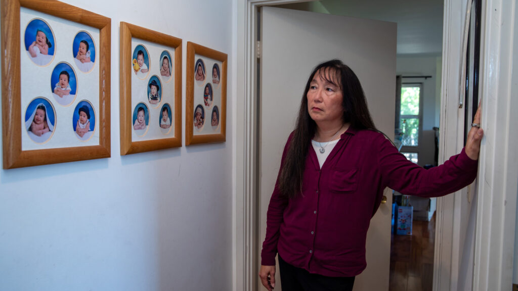 Angela Tang, whose son came down with a baffling illness several years ago, looks at baby pictures of her three children at their home in the Los Angeles suburbs.