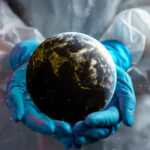 Scientist holding planet Earth in gloved hands