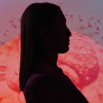 Female silhouette on colorful backdrop with sun sign