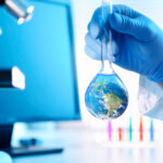 A scientist holding a flask with an image of the earth