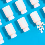 White pill bottles on blue background