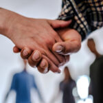 Close-up of patients holding hands supporting each other during group therapy session