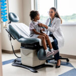 Female doctor listening to young girl's heart in exam room