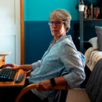 erin mccanlies sits at a brown desk