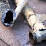 Close-up of a discarded lead pipes on tiled floor