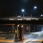 a coyote runs across a train bridge at night