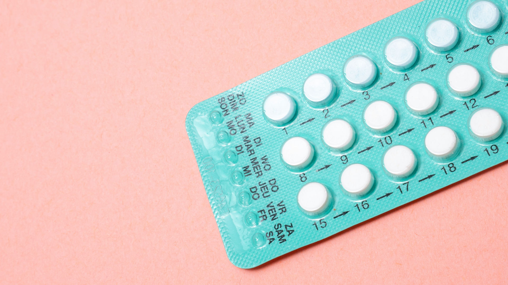 birth control pills on a pink background