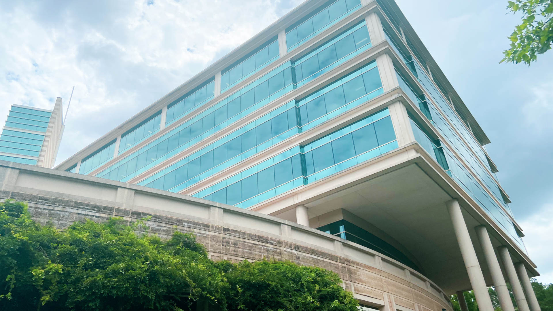 a large office building with many teal-colored windows