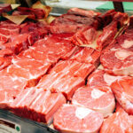 raw cuts of beef on display in a grocery case