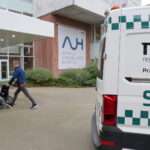 a hospital entrance with ambulance out front