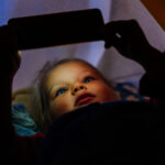 Young girl using mobile phone for watching a short movie.