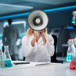 woman in a science lab holding up a megaphone