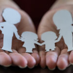 paper cut out family held in hands