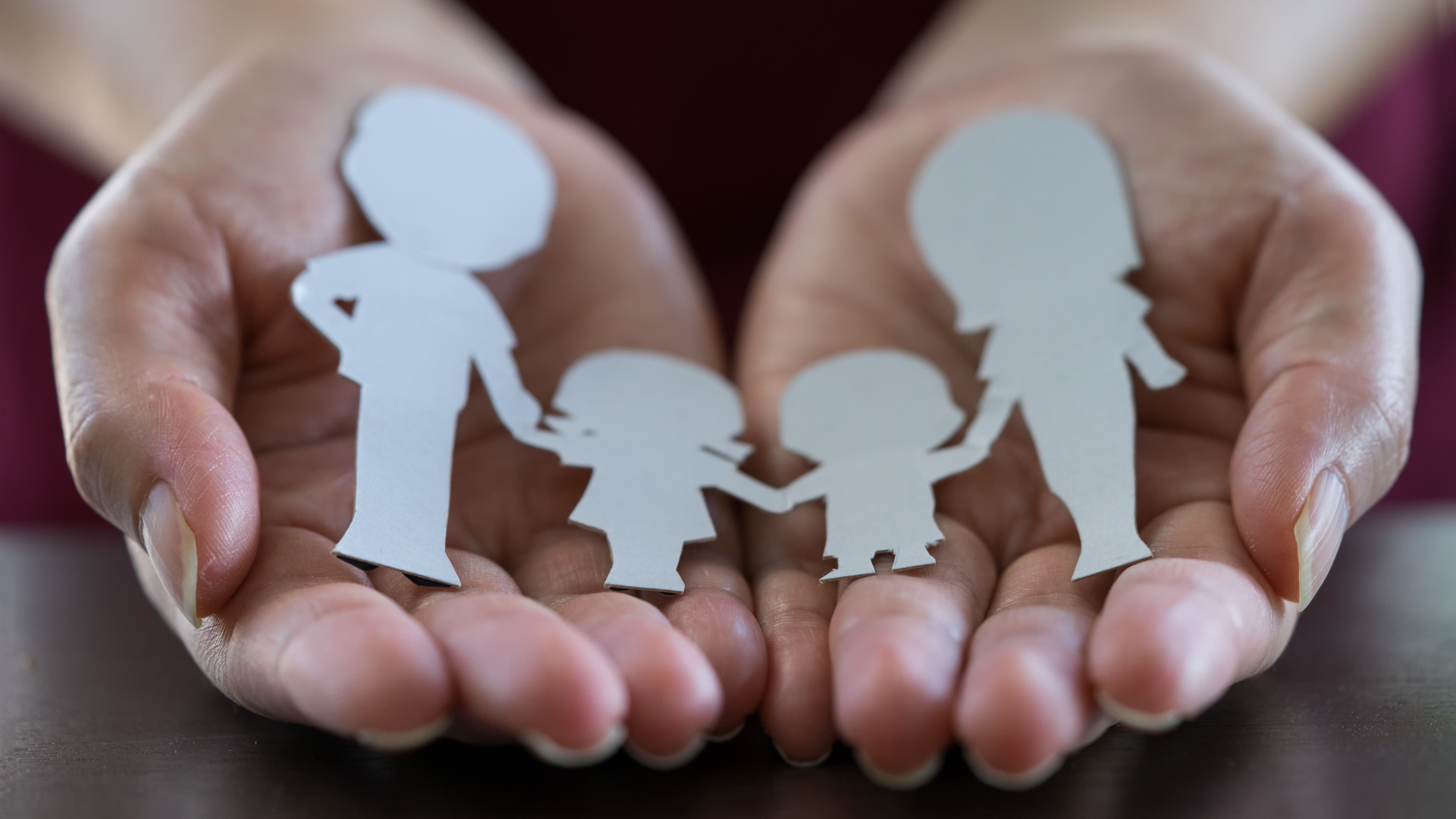 paper cut out family held in hands