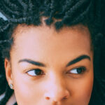Close-up of face of pensive young African-American woman with braids