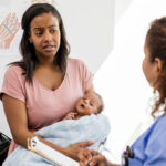 A young mother holds her baby while talking to a doctor. Concern is evident on the mother's face.