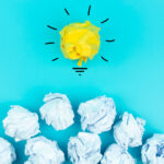 Crumpled Paper light bulb on blue background.